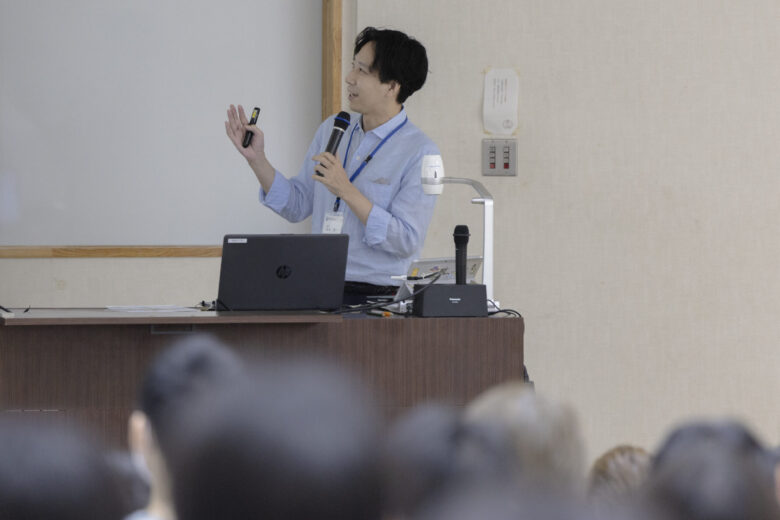 全体会で学部説明を行う松本竜一准教授